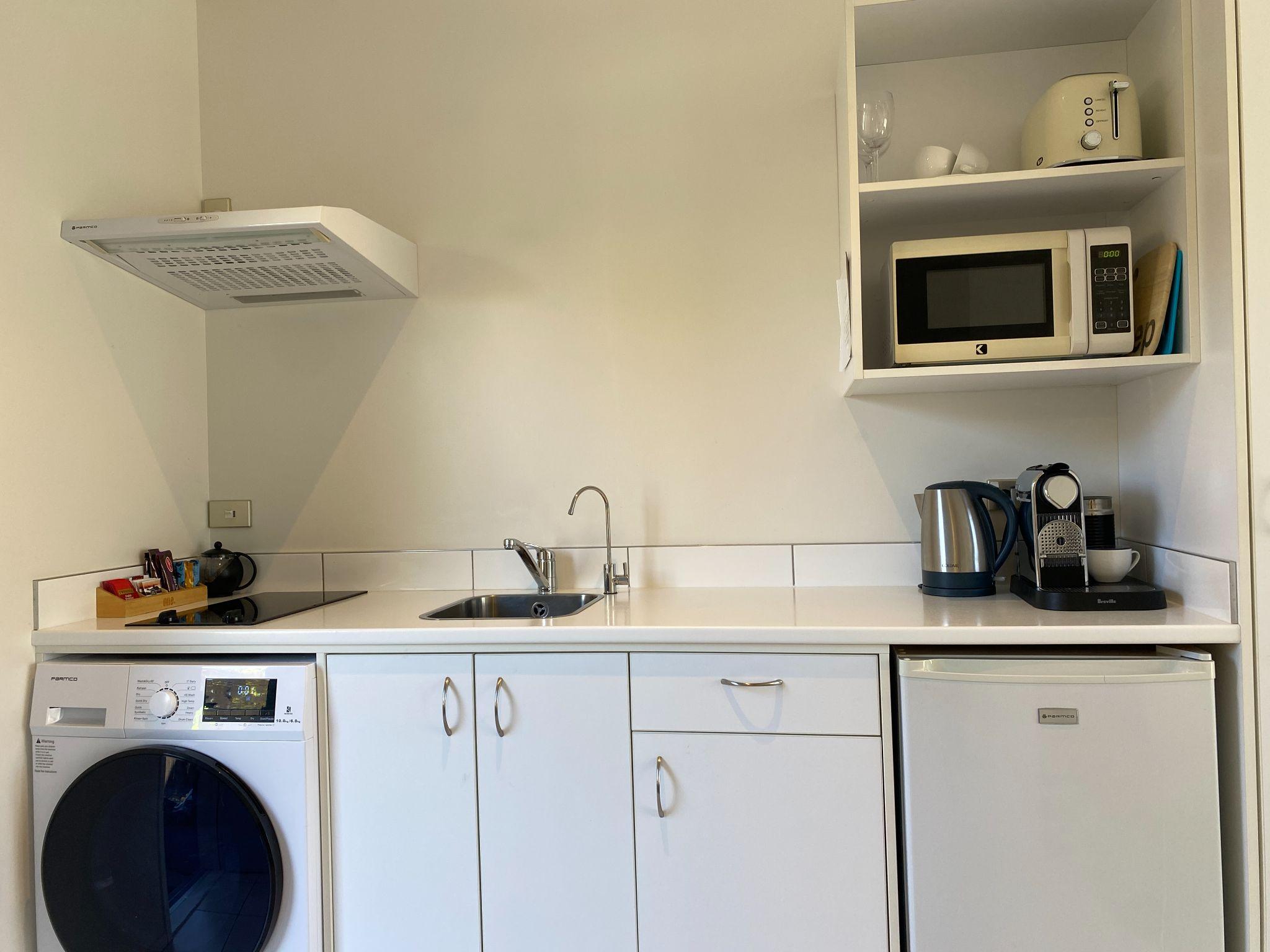 Compact kitchen with washer dryer stove microwave and fridge