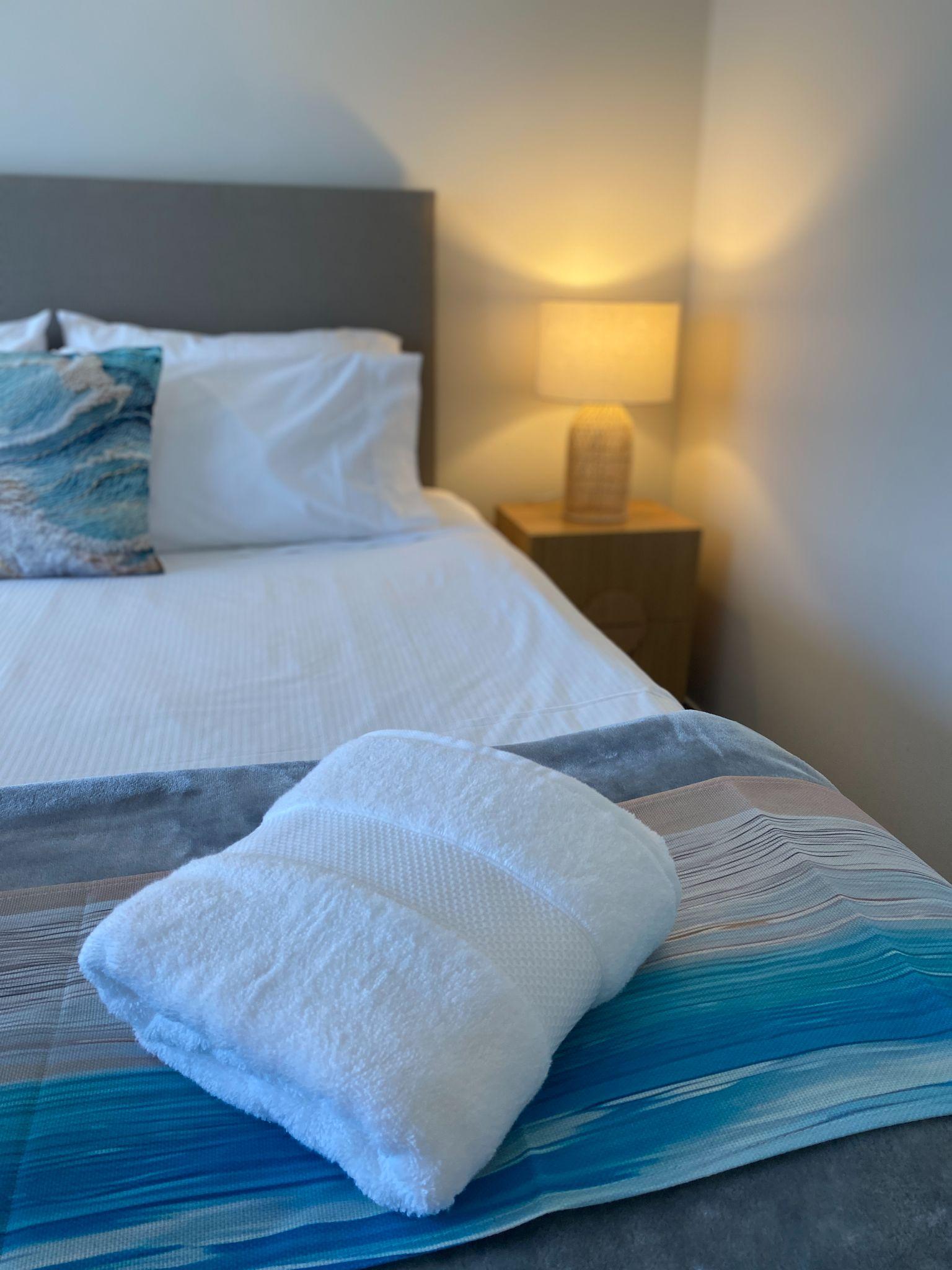 Queen bed with fresh linen and fresh towels